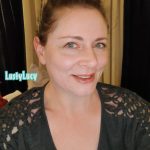 Cam model and content creator LustyLucy smiling with her teeth, her make up looking pretty and her green eyes bright and smiling.